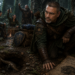 Frank Jamison portrayed as a vigilant D&D-style ranger kneels beside a hidden burrow in a misty forest ruin, dressed in weathered leather and forest-green ranger gear while the rest of his adventuring party celebrates a supposed victory near a campfire in the background. With a wary expression, Frank watches as a scaly creature quietly escapes underground, reinforcing the theme of The Bug Hunter’s Codex, Part IX: The False Victory, where the danger may not truly be gone.